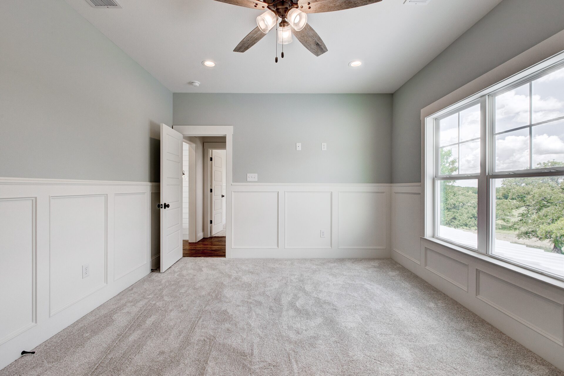 Cedar Elm custom home bedroom with wainscoting and vaulted ceiling by RBCS Inc in North Texas