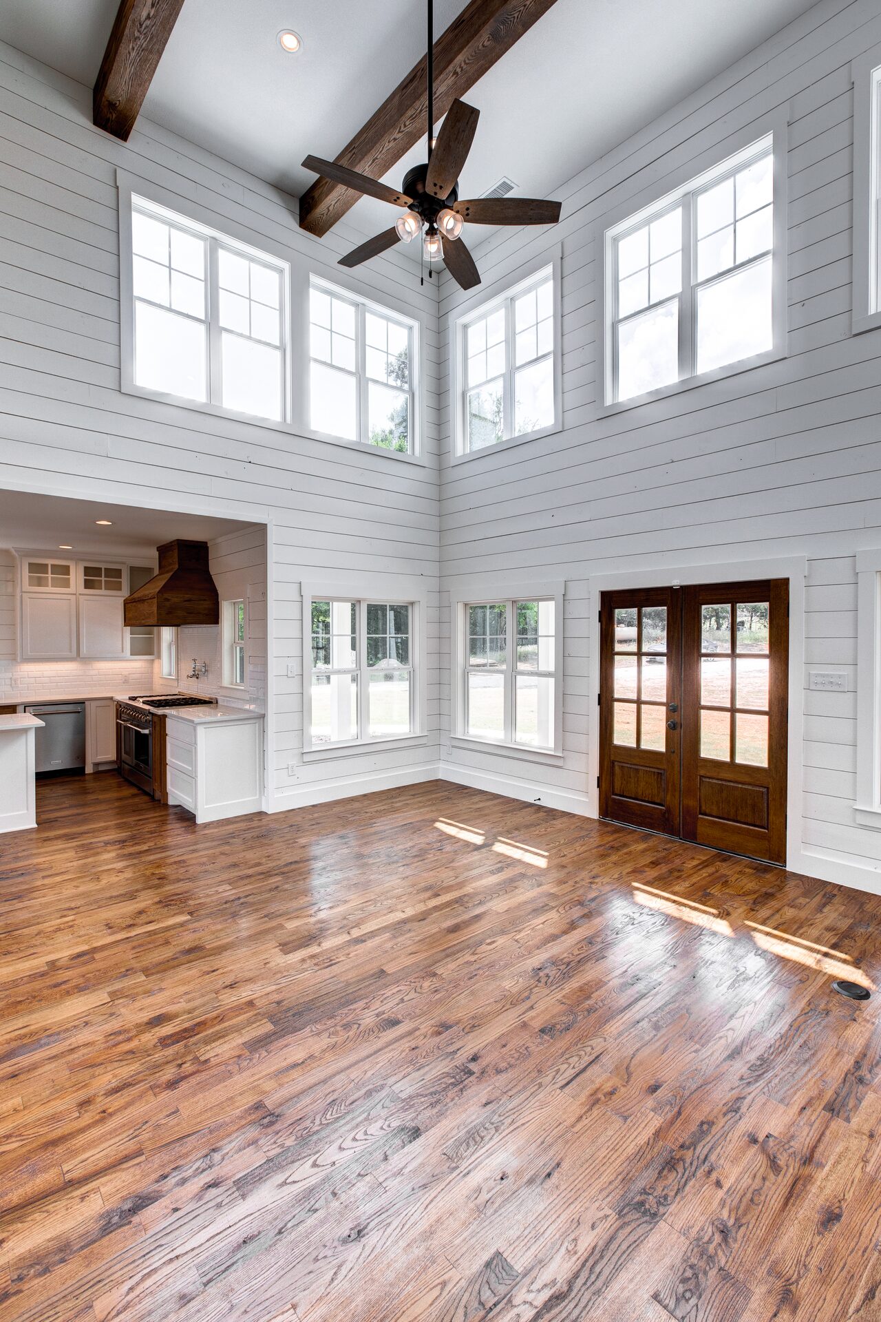 Cedar Elm custom home great room with two-story ceilings and hardwood floors by RBCS Inc in North Texas