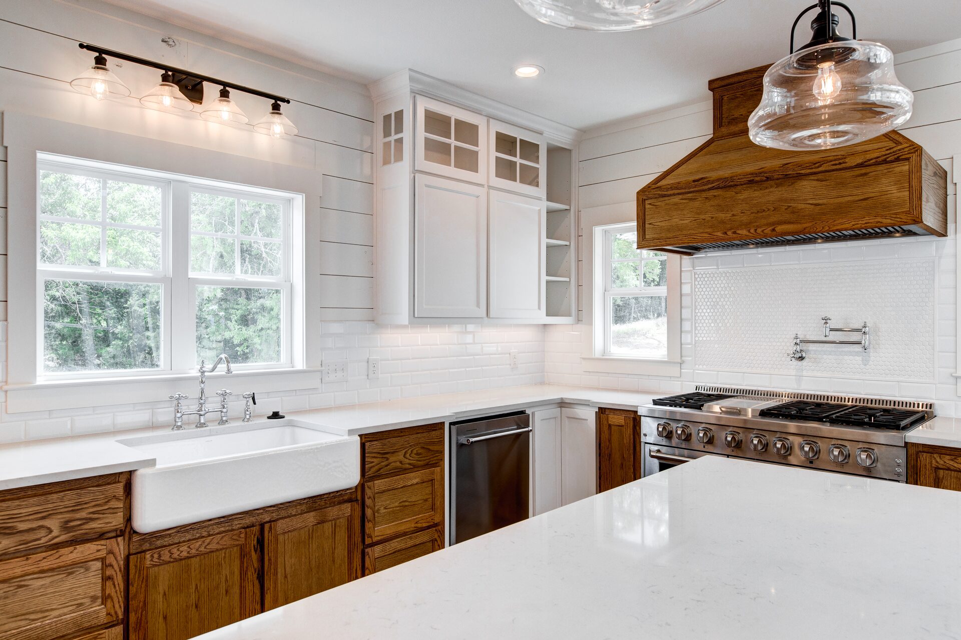 Cedar Elm custom home kitchen with farmhouse sink and shiplap walls by RBCS Inc in North Texas