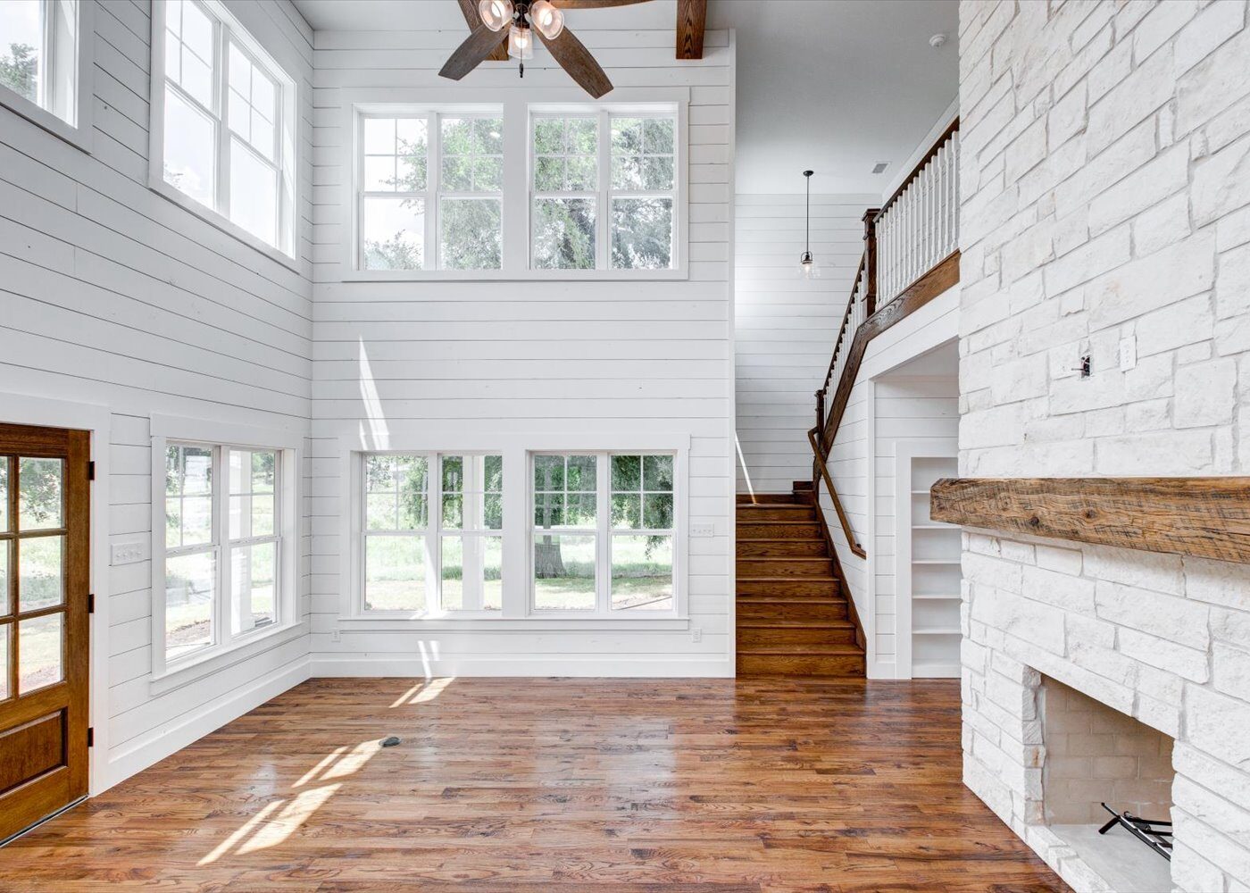 Cedar Elm custom home living room with stone fireplace and shiplap by RBCS Inc in North Texas