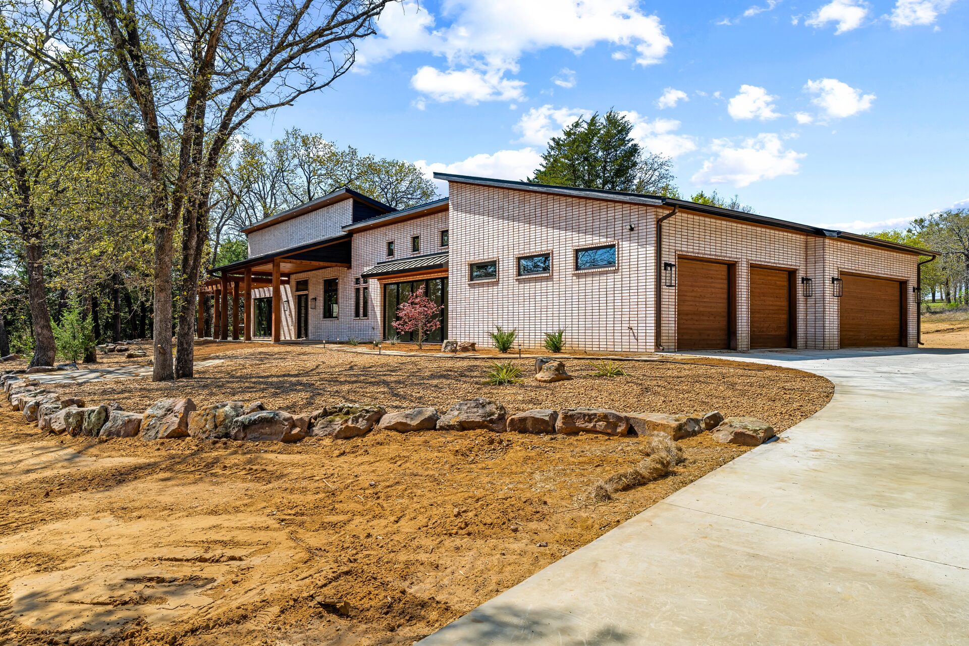 Modern brick and wood custom home exterior by RBCS Inc in North Texas
