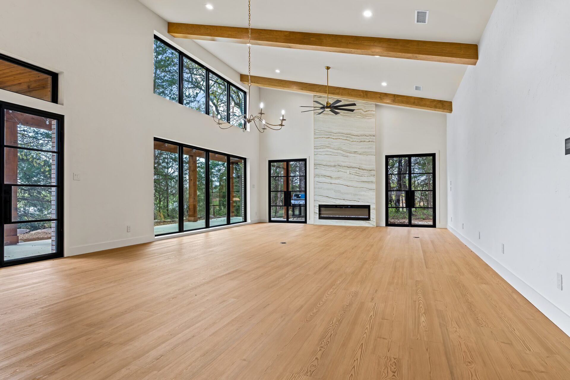 Ironwood custom home great room with vaulted beamed ceiling and marble fireplace by RBCS Inc in North Texas