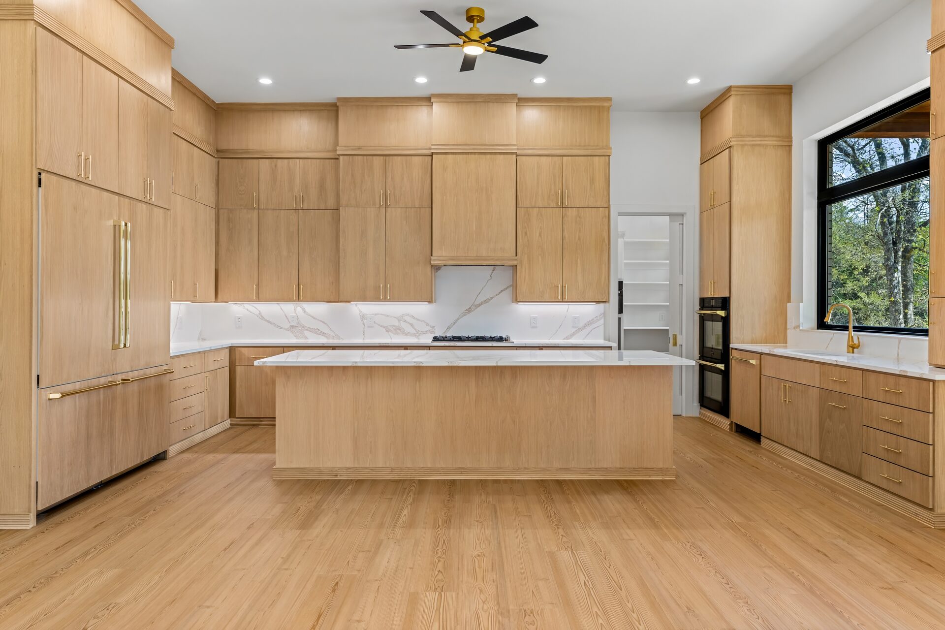 Ironwood custom home kitchen with natural wood flat panel cabinets and quartz island by RBCS Inc in North Texas