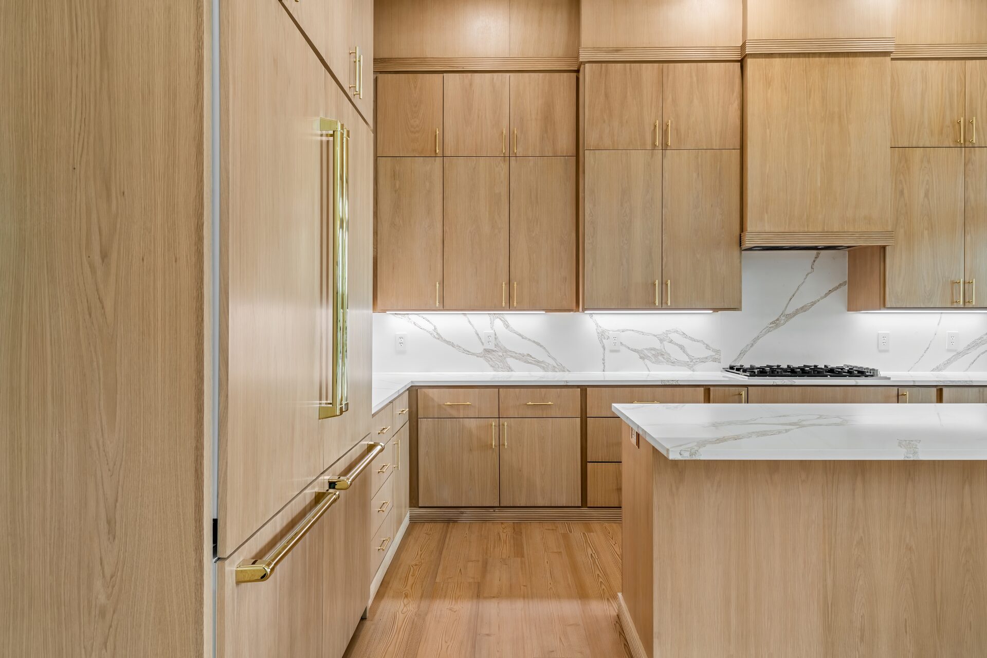 Ironwood custom home kitchen with wood cabinets, marble backsplash, and gold hardware by RBCS Inc in North Texas