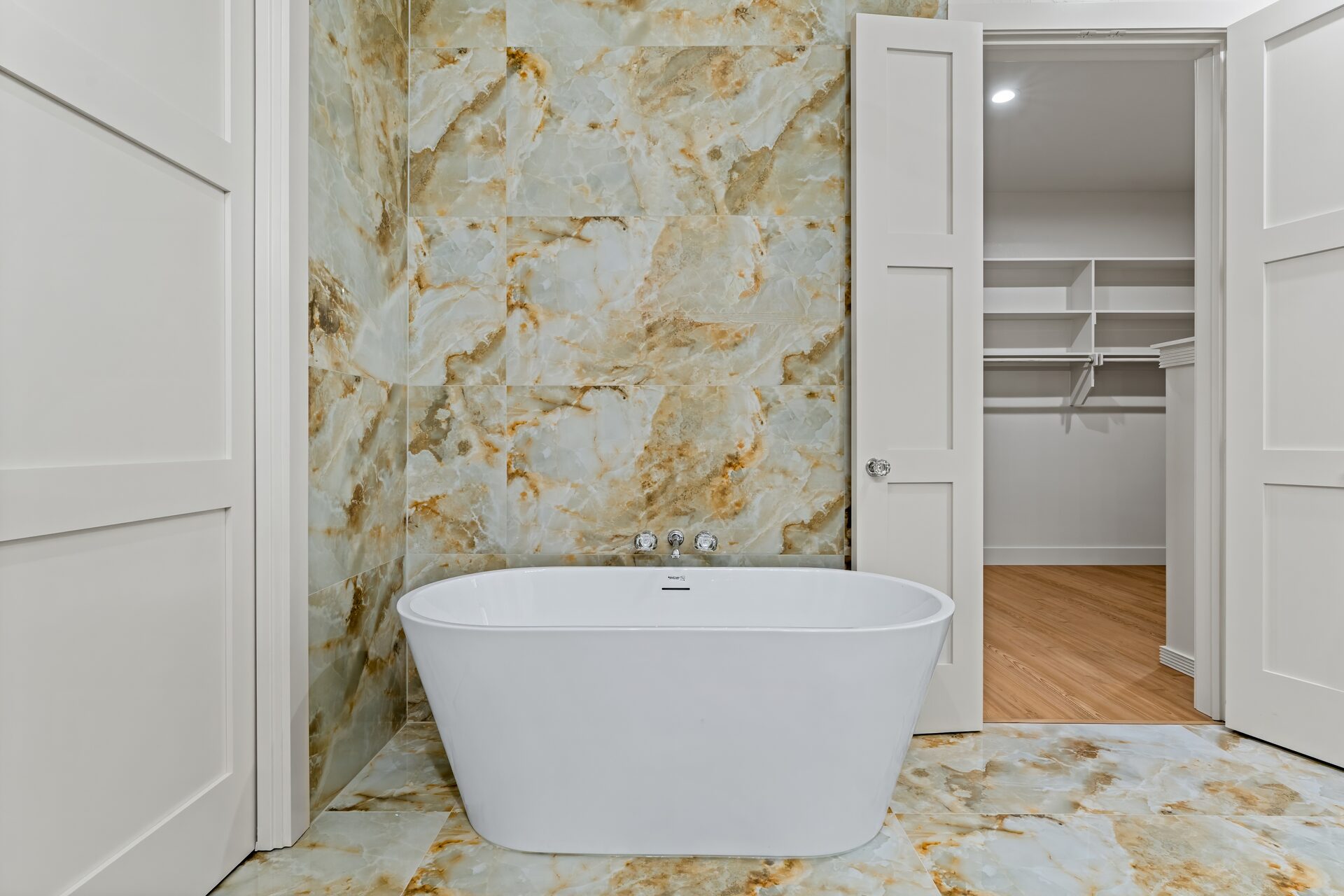 Ironwood custom home master bath with soaking tub and onyx marble tile wall by RBCS Inc in North Texas