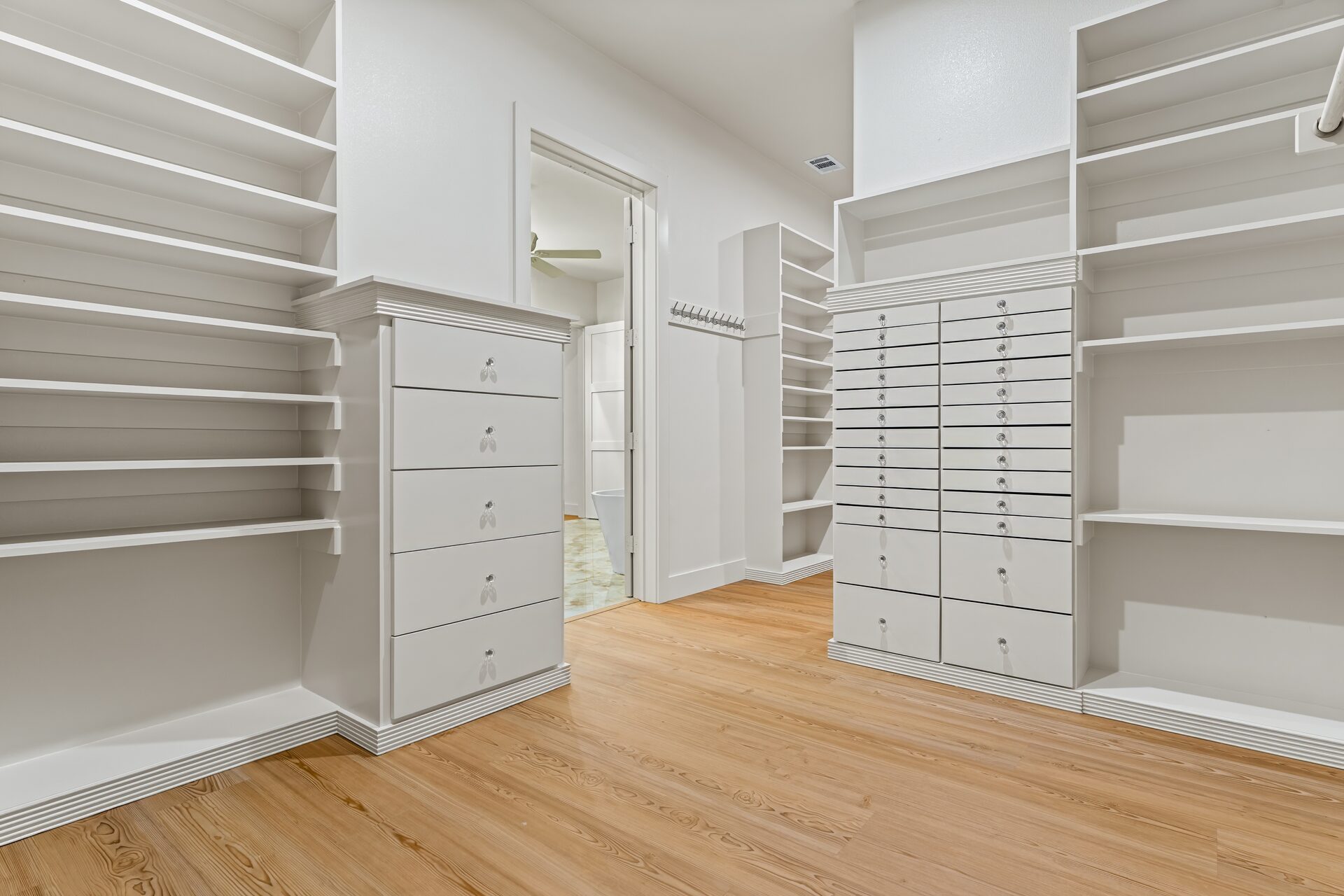 Ironwood custom home walk-in closet with built-in shelving and drawers by RBCS Inc in North Texas