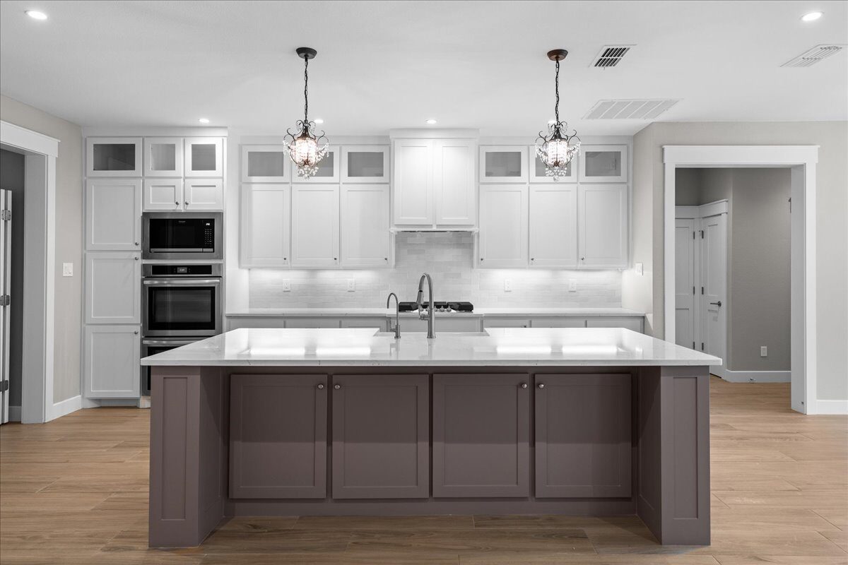 Post Oak custom home kitchen with farmhouse sink and gas range by RBCS Inc in North Texas