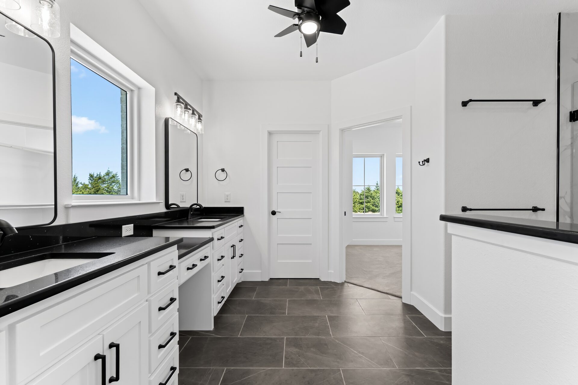 Silverado custom home master bath with double vanity and black hardware by RBCS Inc in North Texas