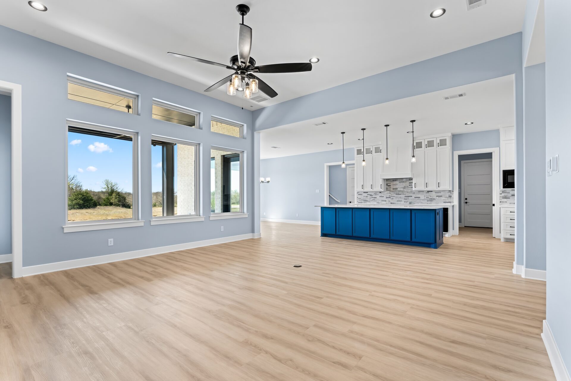 Silverado custom home open concept living and kitchen with blue island by RBCS Inc in North Texas