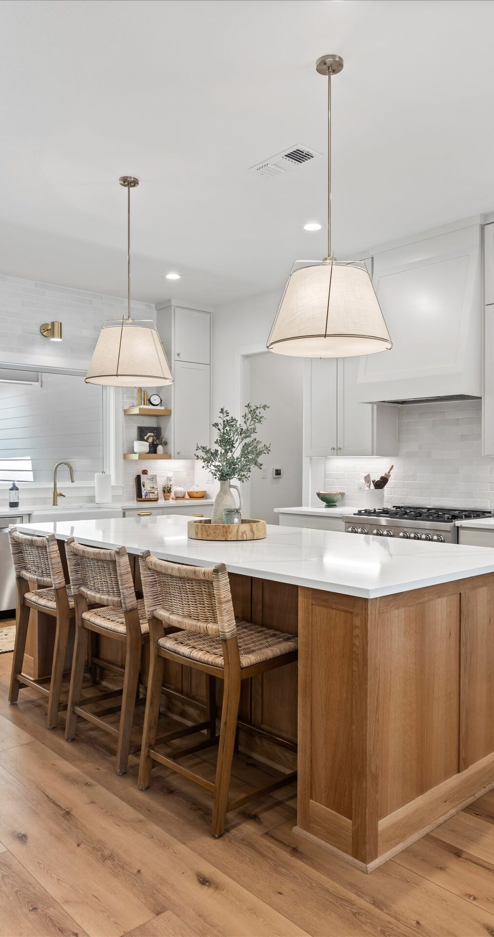 Willow custom home kitchen with wood island and linen pendant lights by RBCS Inc in North Texas